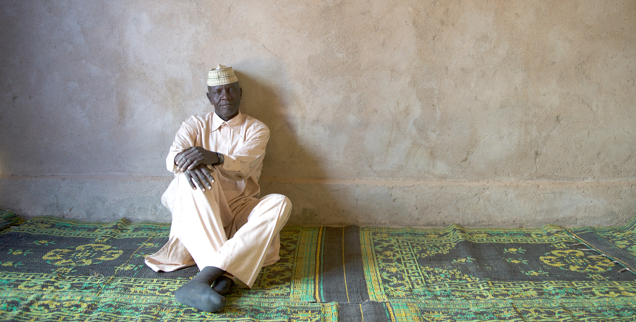 Man sitting against a wall example of where gifts go when you give to TEAM Canada